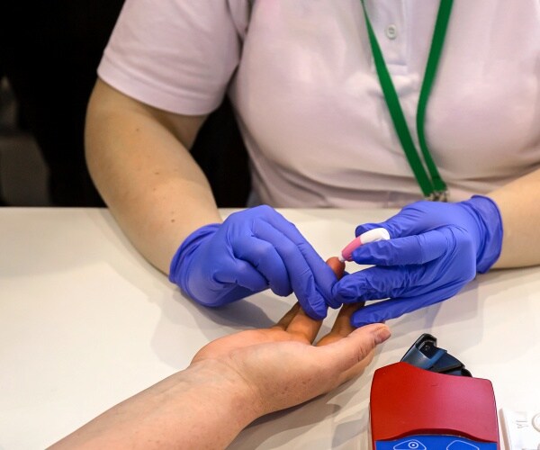 healthcare worker doing a blood prick test on patient