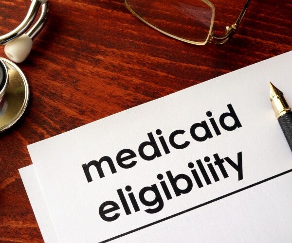 form with heading 'Medicaid Eligibility', pen, glasses, stethoscope