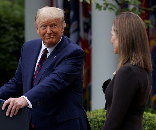 president trump smiles at justice amy coney barrett