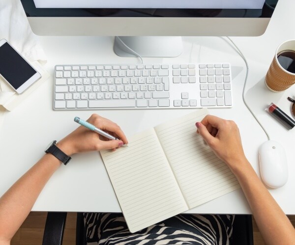 woman at desk at work writing with left hand