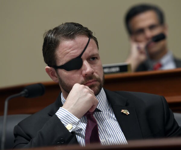 rep. dan crenshaw is shown in a hearing wearing a black eye patch over his right eye