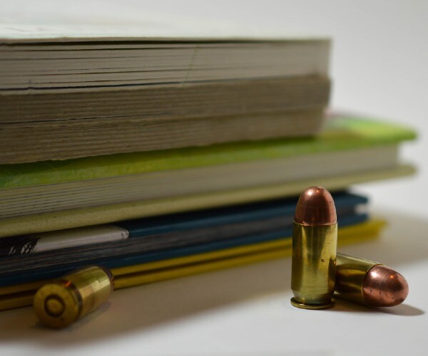 a stack of books next to three bullets