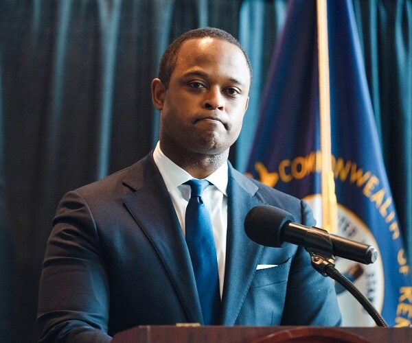 daniel cameron stands behind podium