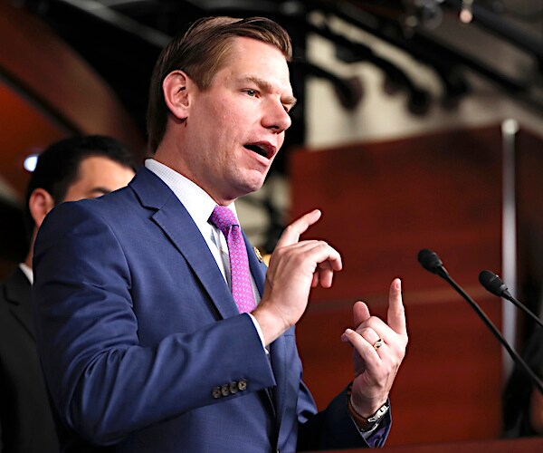 eric swalwell gestures with both hands while addressing the media during a news conference