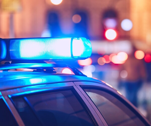 police car with lights on a city street