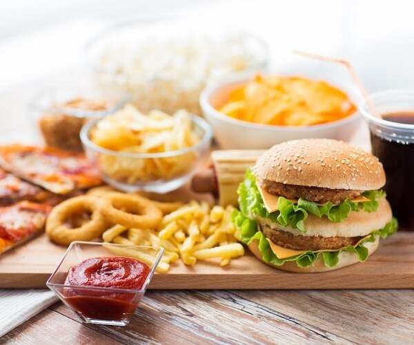a large spread of ultra-processed foods including pizza, hamburger, soda, french fries