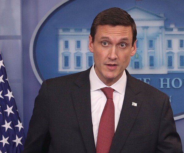 tom bossert stands in front of the white house logo