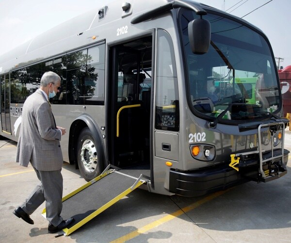 A man boards an electric bus