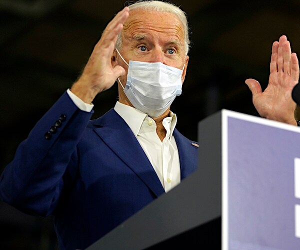 joe biden raises his hands during a campaign speech