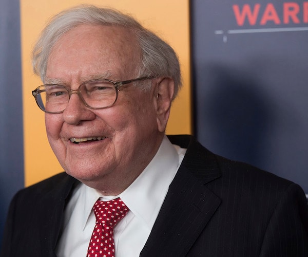 warren buffett smiles during a public appearance on a red carpet