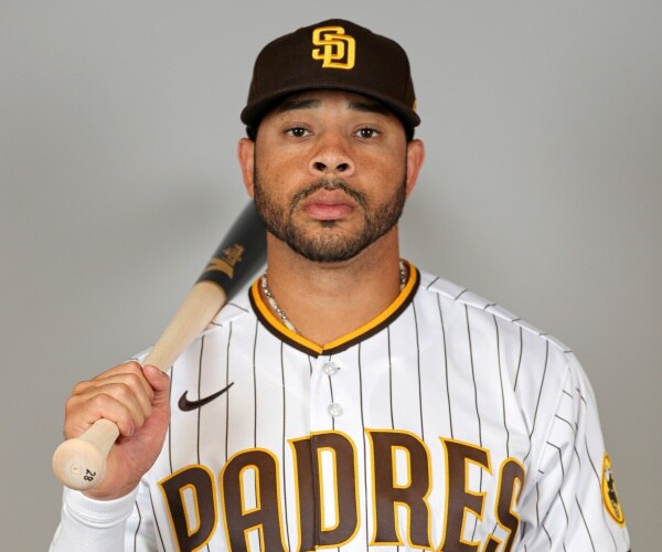 pham in a padres uniform carrying his baseball bat