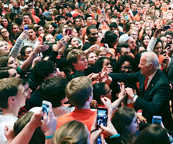 former vice president joe biden is engulfed by students at syracuse university