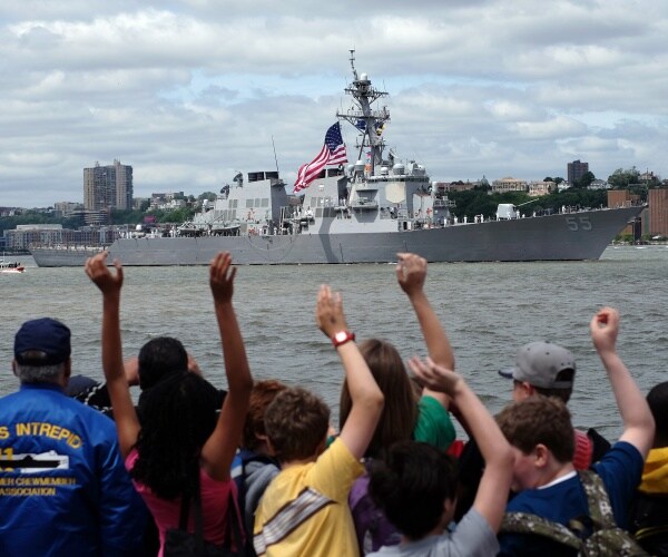 uss stout sails by as people stand and wave