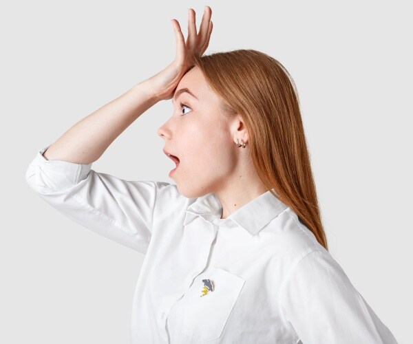 woman slapping forehead because she forgot something