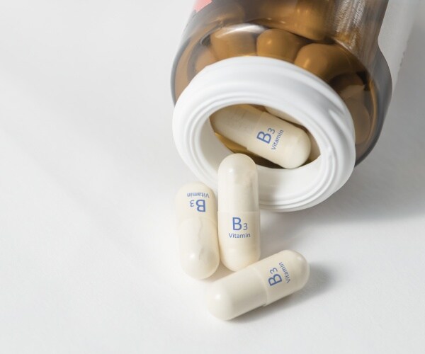capsules labeled vitamin B3 spilling out of container