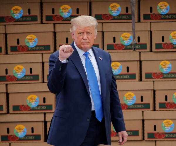 donald trump stands in front of food boxes