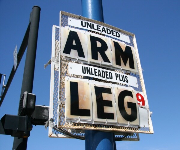 high gas prices are shown by a sign displaying arm and leg