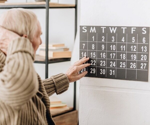 older man looking at calendar in confusion