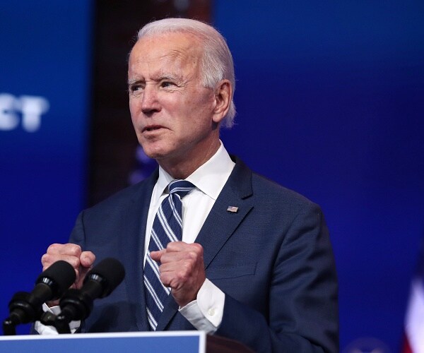 joe biden stands behind podium 