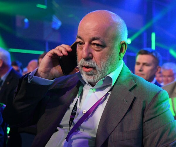 viktor vekselberg holding a phone up to his right ear while speaking into it