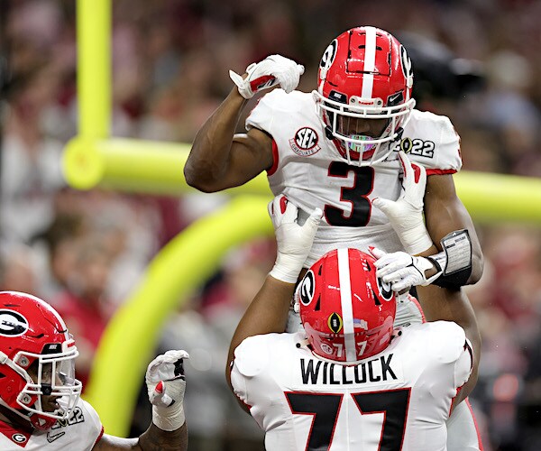 georgia bulldogs football player devin willock lifts up his teammate after a touchdown