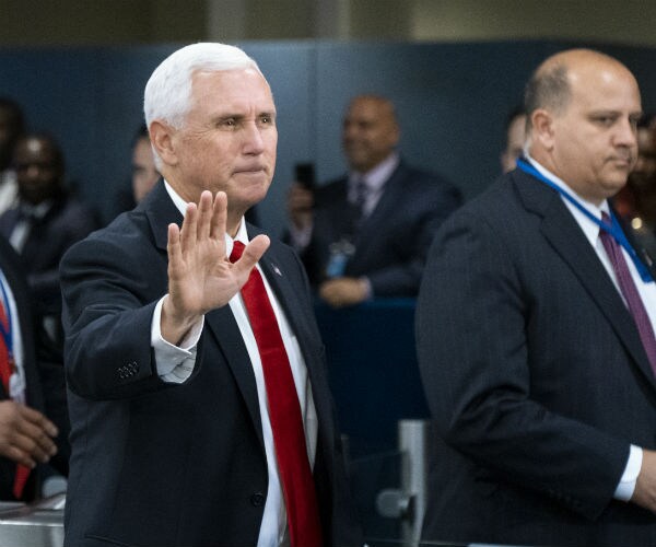 Vice President Mike Pence is shown in dark suit, red tie and dress shirt
