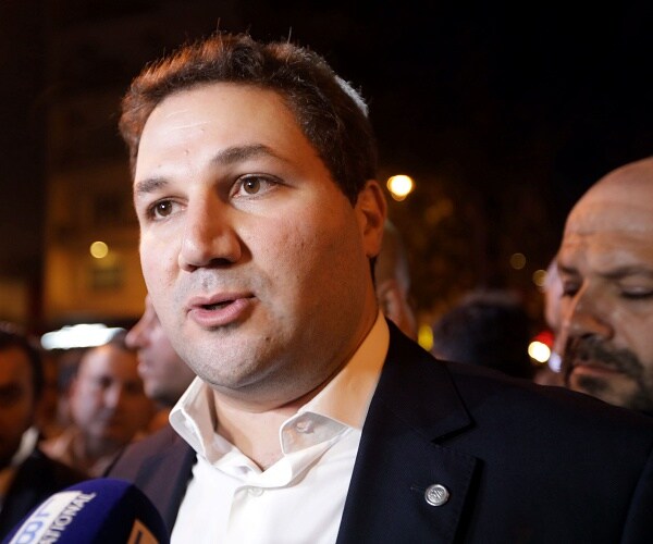 nadim gemayel stands in street at night