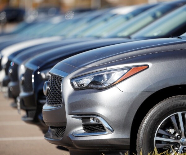 a long line of unsold 2018 QX60 sports-utility vehicles sits at an Infiniti dealership