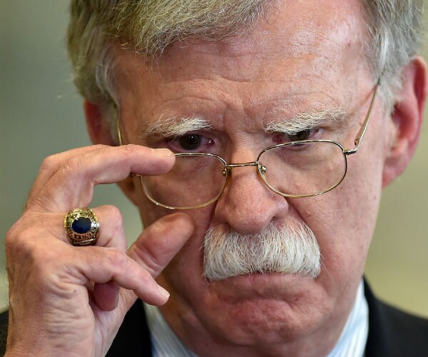 john bolton is shown adjusting his glasses