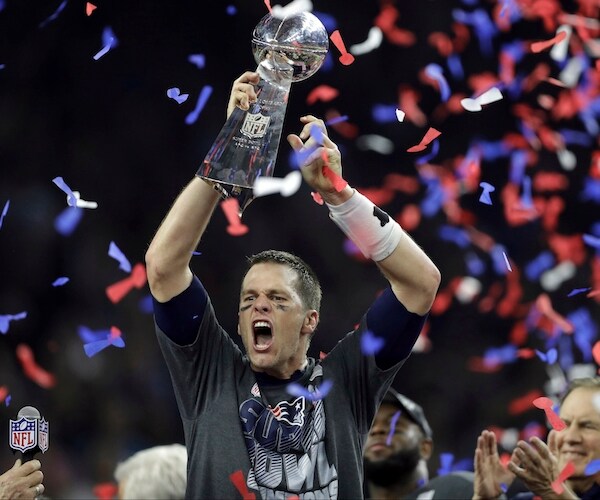tom brady hoists one of his seven super bowl trophies