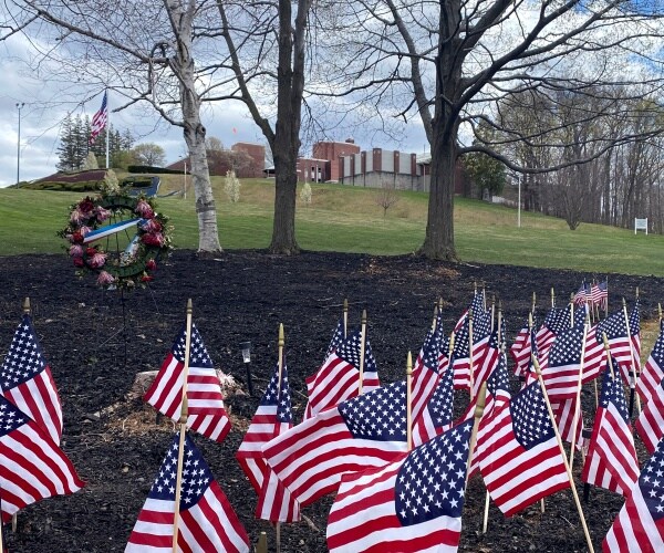 many small american flags and wreaths are seen in the ground outside in holyoke, massachusetts