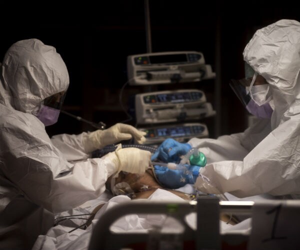 two hospital workers are shown in personal protective gear