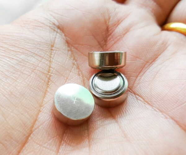 button batteries in a person's hand