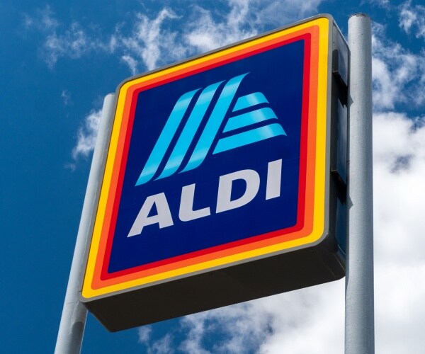 aldi store sign with logo is shown against a blue sky with clouds