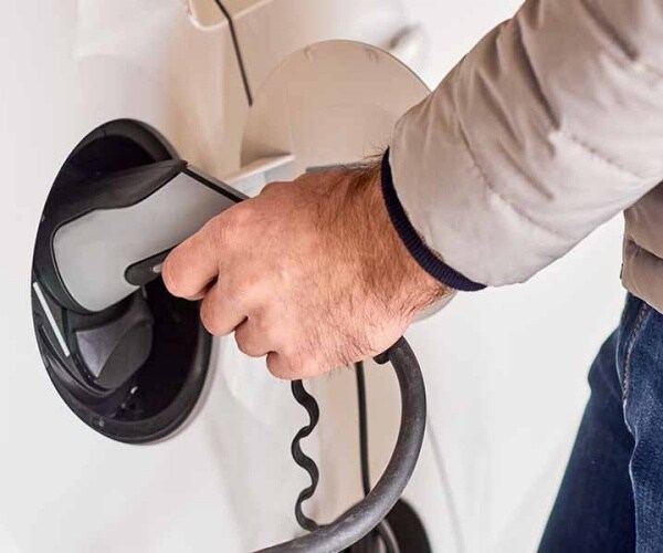 man charging electric car