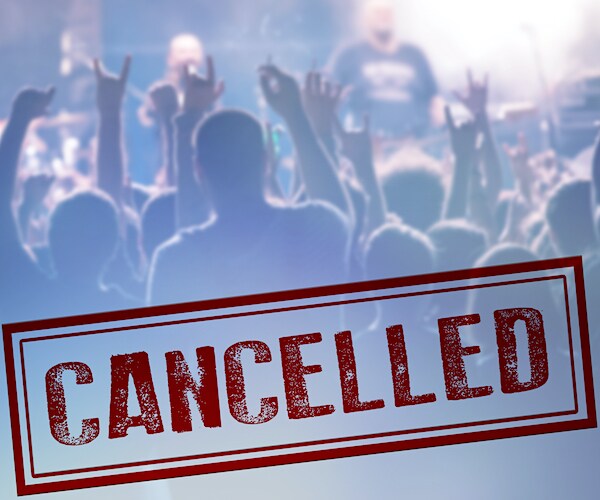 a rock concert crowd covered by a cancellation sign