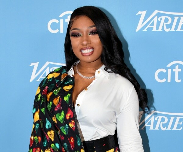 megan thee stallion in a white button down shirt with a colorful patterned accessory