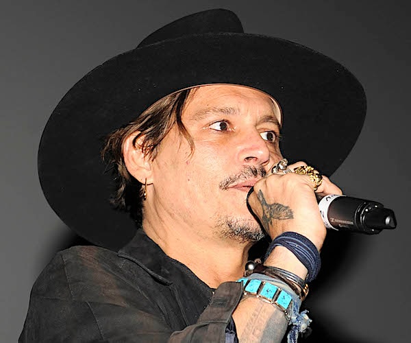 johnny deep speak into a mic on stage