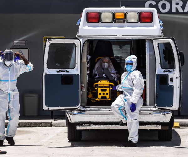 medics standing outside an ambulance with a patient inside