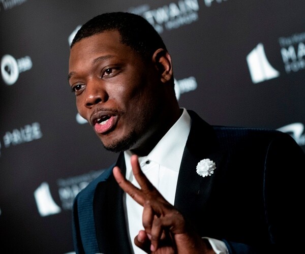 michael che stands on red carpet