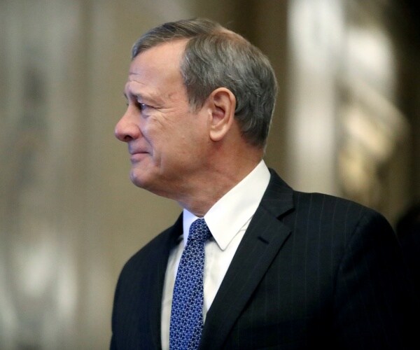 chief justice john roberts in a suit and blue tie