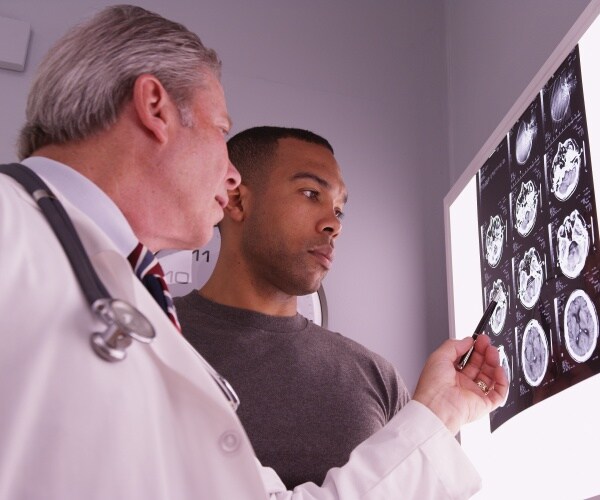 doctor and young man reviewing brain x-rays