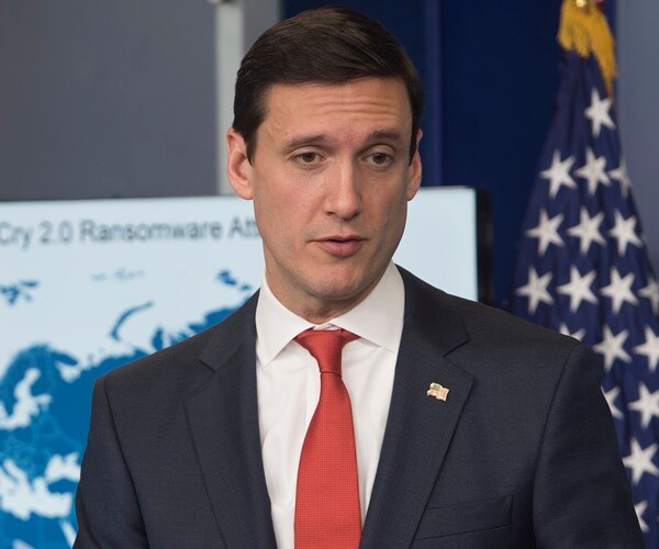 tom bossert stands in front of a map showing the centers of an online virus