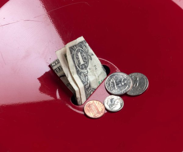 money being placed in a salvation army kettle