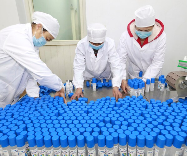 workers in suining, china, pack bottles of disinfectant