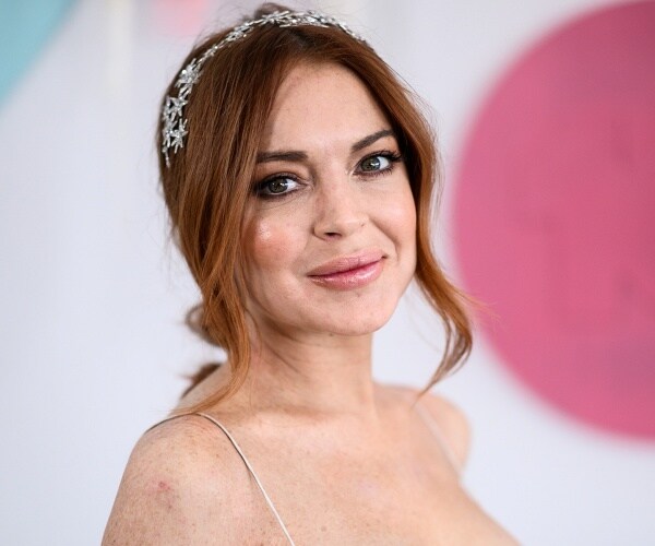 lindsay lohan stands on red carpet