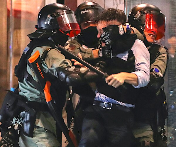 a hong kong protester is corralled by force by police