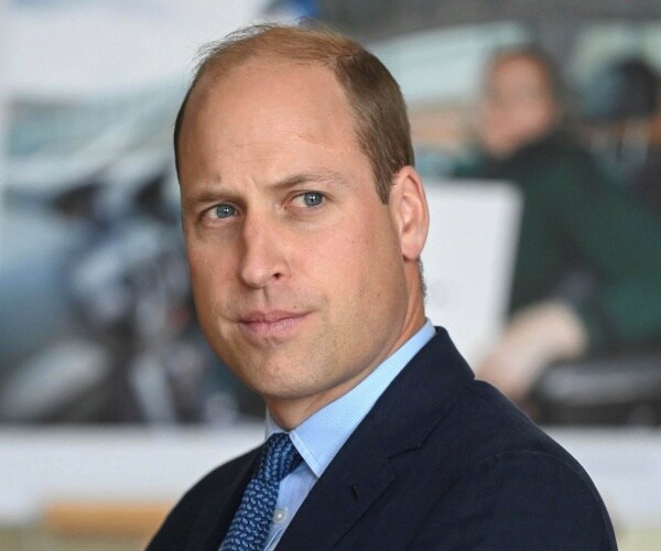 william in a navy blue suit and blue patterned tie