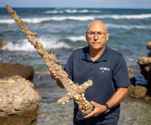 A man holding an ancient sword.