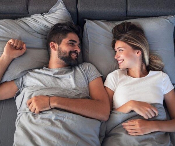 man and woman in bed smiling